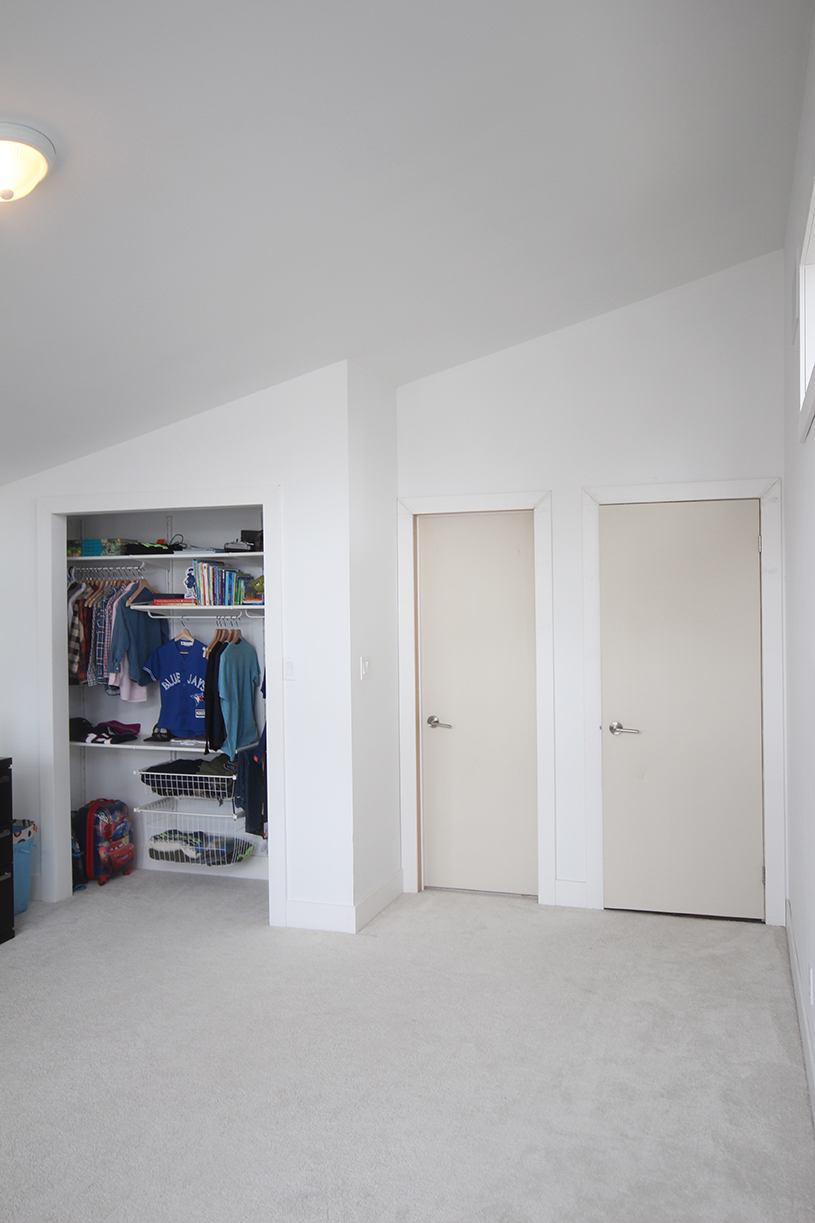 Boys bedroom before: primed hardboard slab doors mark the entrances to the room and en-suite.