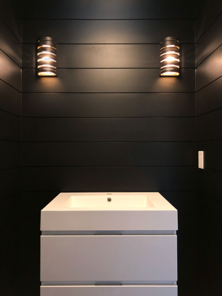 The addition of paint & lighting gives the powder room a beautifully dark & moody vibe.