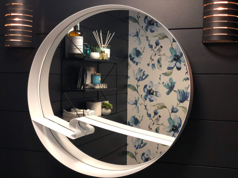 The round mirror is a perfect choice to soften the straight lines of the shiplap and the contrasting white colour helps it to pop against the dark walls