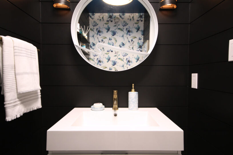 Love how the mirror reflects the contrasting patterned wallpaper bringing it into the forefront of the space